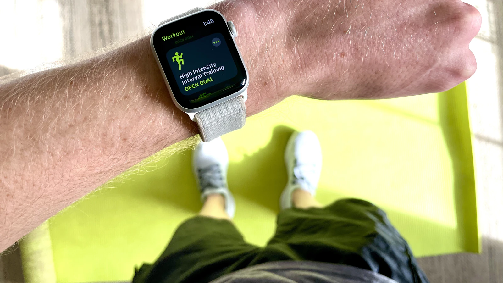 A silver Apple Watch with a white sport band