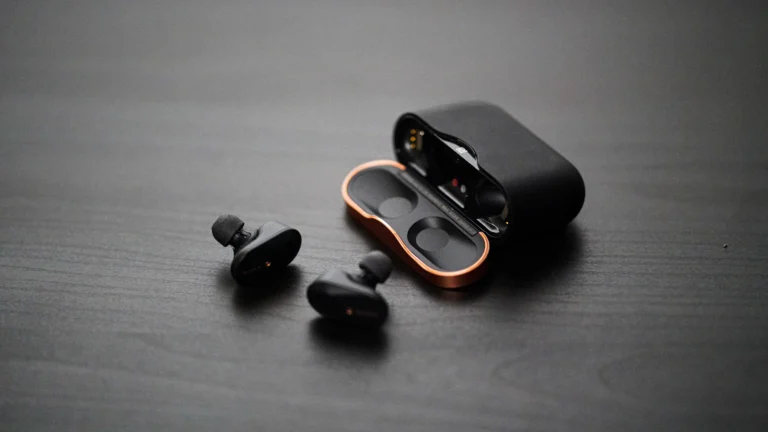 Sony wireless earbuds next to their charging case