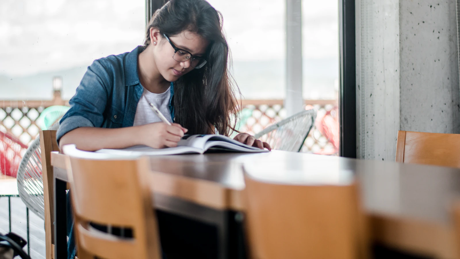 A student writing notes in a notebook while studying